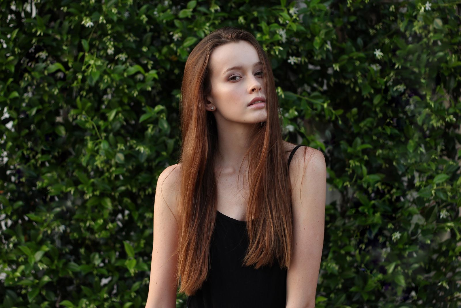 Portret van een vrouw voor een groene haag