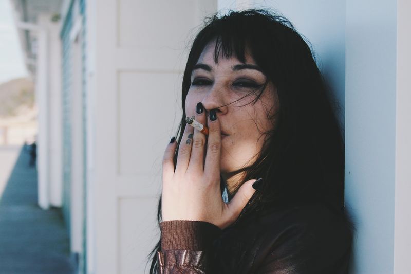 Portret van een vrouw tegen een witte gevel
